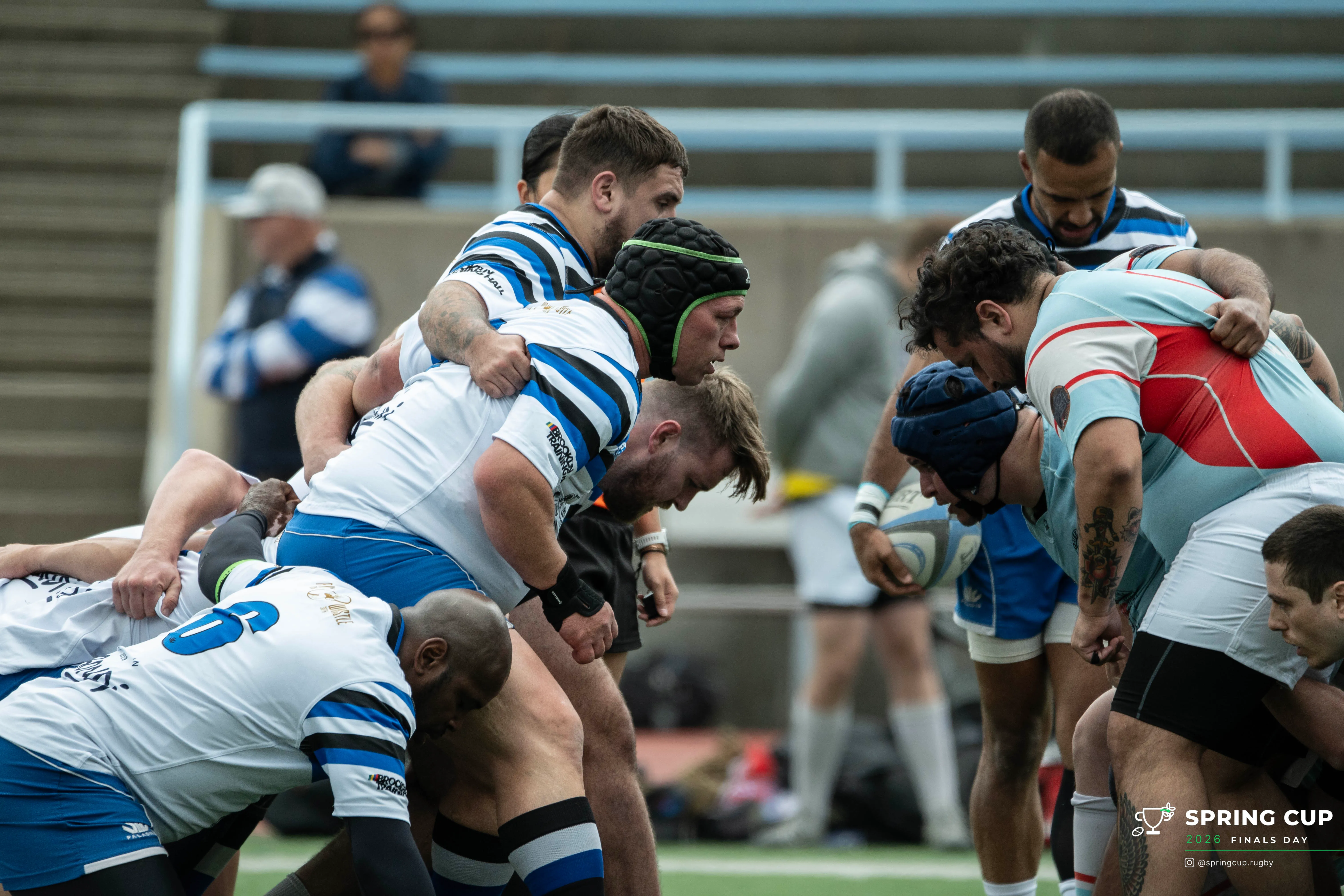 Two front rows engage at a scrum under the referee’s call